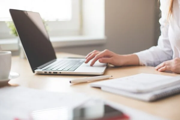 Grant writing materials beside a laptop